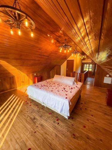 a bedroom with a bed in a wooden room at Cabanha Sítio Gomes in Canoinhas