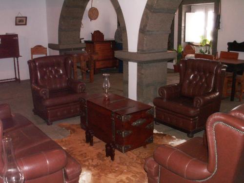 salon ze skórzanymi krzesłami i stołem w obiekcie Quinta Do Martelo w mieście Angra do Heroísmo