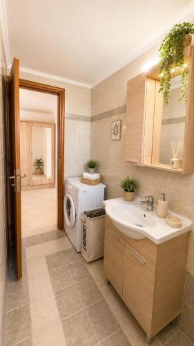 a bathroom with a washing machine and a sink at Théa Loft Premium Sunset Sea View Escape in Vathý
