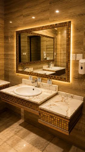 a bathroom with two sinks and a large mirror at Qasr Arin Aprtments For Serviced Apartments شقق قصر ارين للشقق المخدومة in Jeddah