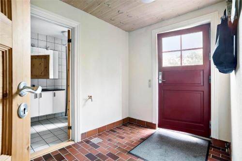 a bathroom with a red door and a tile floor at LF13030-Karby-Agerovej-44 in Karby