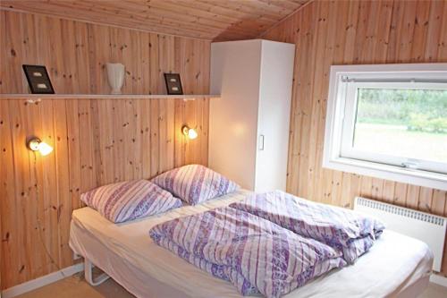 a bedroom with a bed with two pillows and a window at LF15018-Skals-Lynderup-Strand-4 in Skals