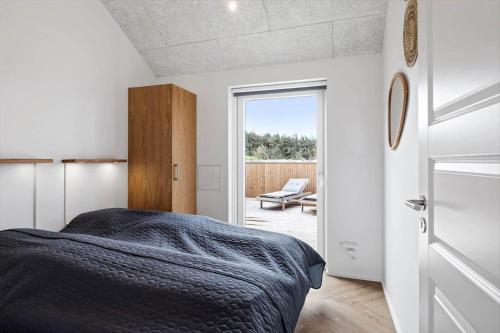 a bedroom with a bed and a door to a patio at 391-Harboore-Slettevej-33 in Harboør