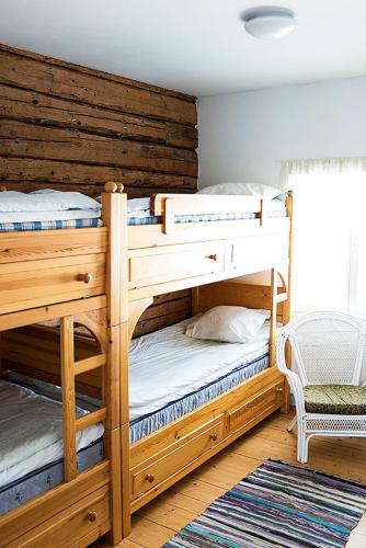 two bunk beds in a room with a wooden wall at Ilmaristen Matkailutila in Lieto