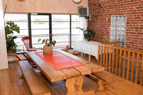 um quarto com uma mesa de madeira e uma parede de tijolos em Ilmaristen Matkailutila em Lieto