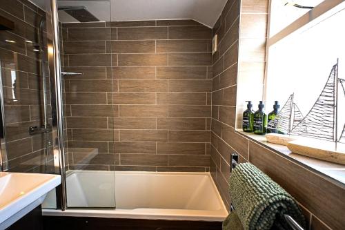 a bathroom with a shower and a sink and a tub at Stade Cottage in Hythe