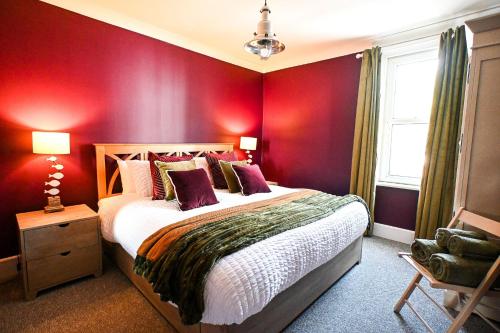 a bedroom with red walls and a large bed at Stade Cottage in Hythe