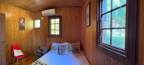 a bedroom with a bed and a red chair at Onda Azul Back Unit A & B in Ponta do Ouro