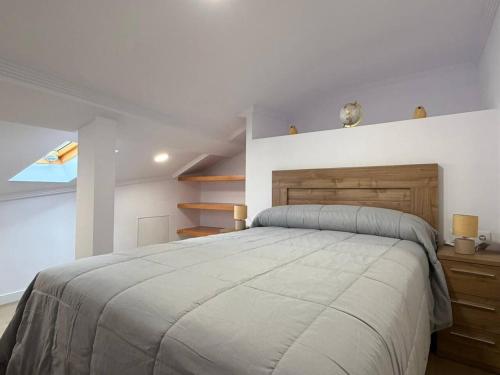 a bedroom with a large bed with a wooden headboard at casa Angelita in Mourillones