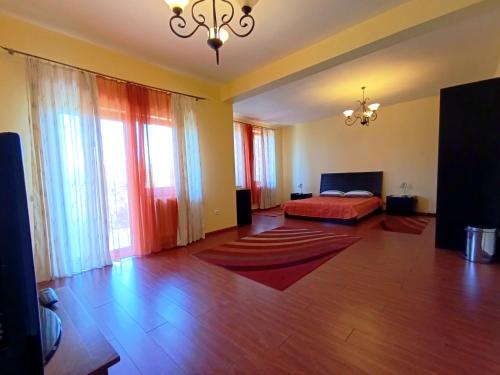a bedroom with a bed and large windows at Pensiunea Ruxandra la 100 m de Aqua Park Venus in Baile Unu Mai