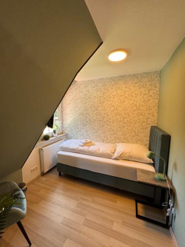 a bedroom with a bed and a chair in a room at Ferienwohnung am Rohrbach in Binnen