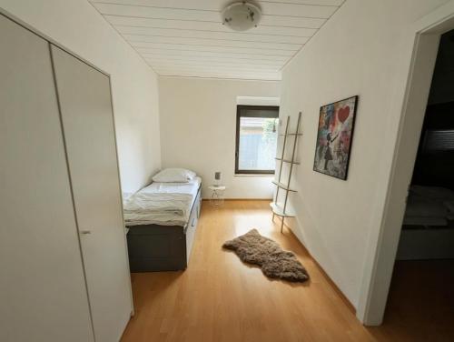 a bedroom with a bed and a rug on a wooden floor at Seemöwe im Haus Windrose in Butjadingen