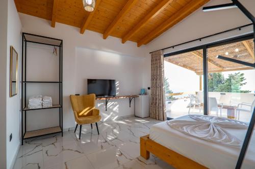 a bedroom with a bed and a tv and a chair at Hotel Panorama Piqeras in Piqeras