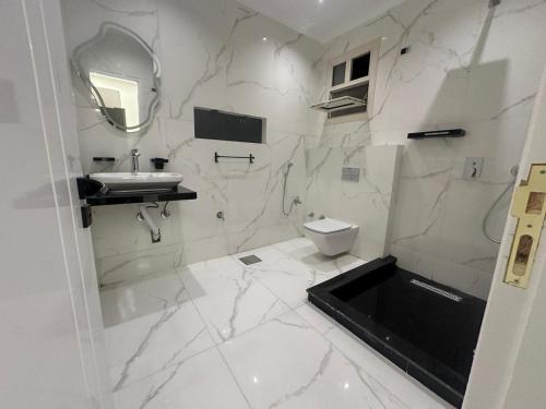 a white bathroom with a sink and a toilet at Karma Kono in Abu Simbel
