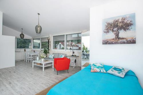 a bedroom with a blue bed and a living room at Dream View Loft in Lithakia