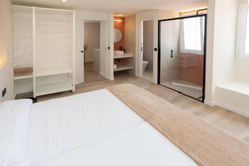 a bedroom with a white bed and a shower at Apartamentos San Antonio Beach in San Antonio Bay