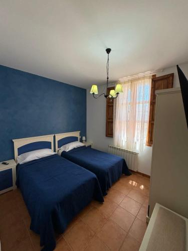 two beds in a bedroom with blue walls at Casa Rural Tronchon in Tronchón