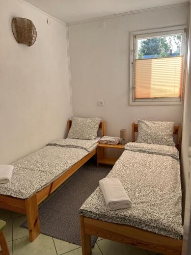 a room with three beds and a window at Agroturystyka Uroczysko Kostomłoty in Kostomłoty
