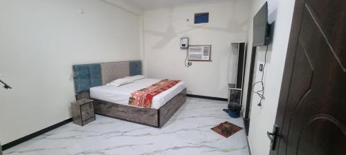 a bedroom with a bed and a tiled floor at Anusthan Hotel in Ūnchāhar