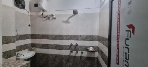 a bathroom with a sink and a toilet at Anusthan Hotel in Ūnchāhar