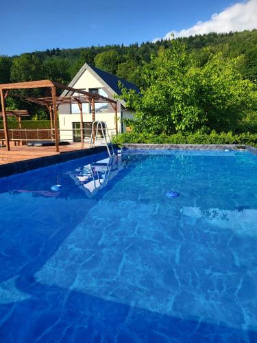a large blue swimming pool with a slide at Domki u Duszy Wielka Dusza in Brenna