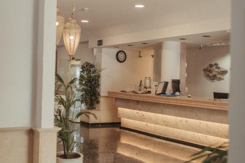 a bar in a restaurant with a clock on the wall at Hotel ROC Oberoy - Adults Only in Paguera