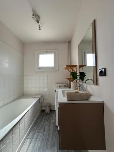 a bathroom with a tub and a sink and a mirror at Pause détente à Aubenas in Aubenas