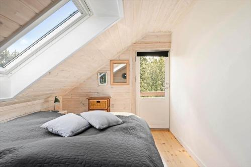 a bedroom with a large bed with a window at LF15156-Hojslev-Mosevej-156 in Højslev