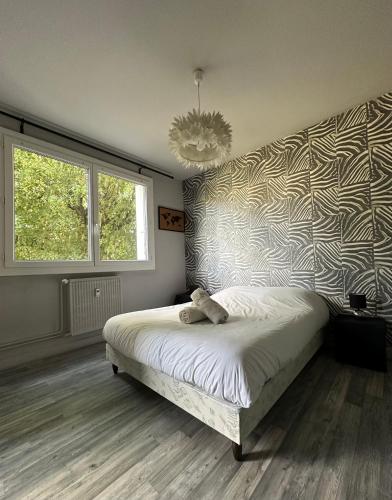 a bedroom with a bed with a zebra print wall at Pause détente à Aubenas in Aubenas
