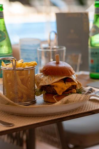 a sandwich and french fries on a plate on a table at Hotel ROC Oberoy - Adults Only in Paguera