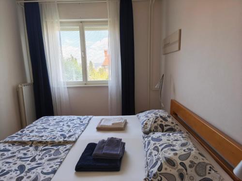 a bedroom with a bed with two towels and a window at Vila Flori in Koper
