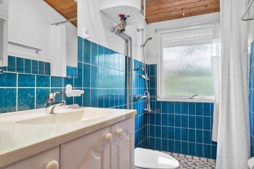 a blue tiled bathroom with a sink and a shower at LF15191-Hojslev-Ternevej-31 in Højslev