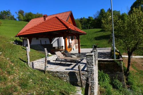 a gazebo with a chair sitting on a stone patio at Valley View Holiday Home with Sauna Mrak in Slap ob Idrijci