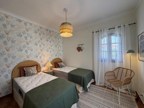 a bedroom with two beds and a chair at Three Sisters in Altura