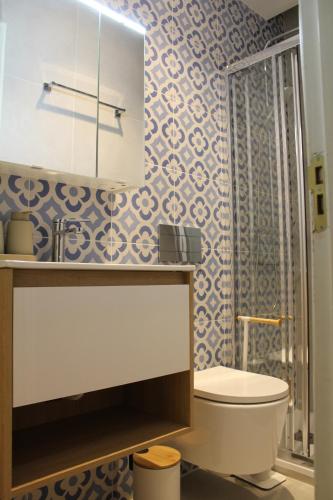 a bathroom with a toilet and a shower with blue and white tiles at Three Sisters in Altura