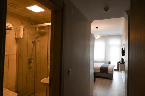 a bathroom with a shower and a bedroom with a bed at Zelif Otel Havza in Havza