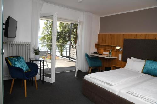 a hotel room with a bed and a desk and chairs at Strandhotel Seehof in Überlingen