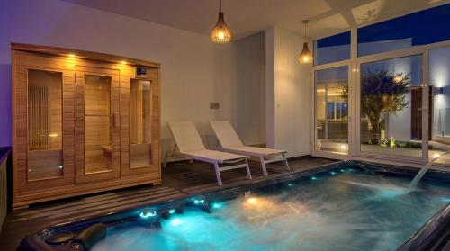 a swimming pool in a room with a table and chairs at Maltese Luxury Villas - Sunset Infinity Pools, Indoor Heated Pools and More! in Mellieħa