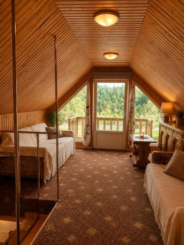 a bedroom with two beds and a large window at Peaceful Nature Cottage near Talsi with Hot Tub, Sauna & Pond, Camping Ives in Talsi
