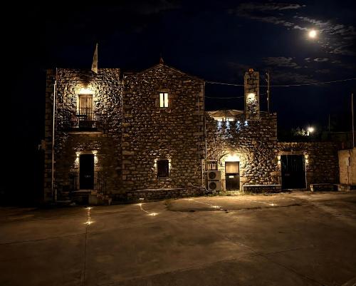 a stone building at night with the moon in the sky at Diaks Tower Sunset Sea View Mani in Pyrgos Dirou