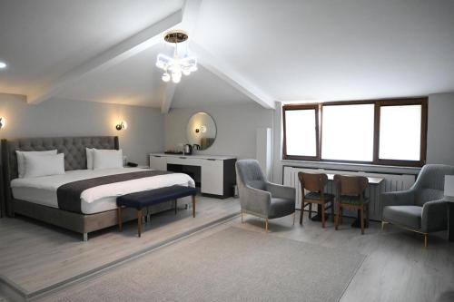 a bedroom with a bed and a table and chairs at Zelif Otel Havza in Havza