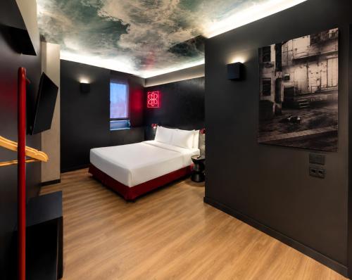 a bedroom with a bed and a painting on the wall at Yomo Hostal BCN Port in Barcelona
