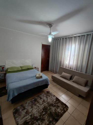 a bedroom with a bed and a couch at Hostel Bauru in Bauru
