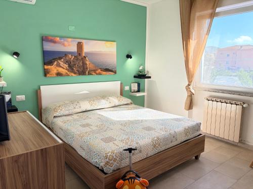 a bedroom with a bed with a painting on the wall at Casa Bea in Palmadula
