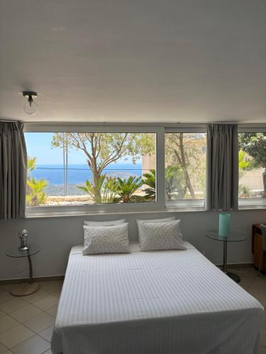a bedroom with a bed with a view of the ocean at Viva B&B in Anavyssos