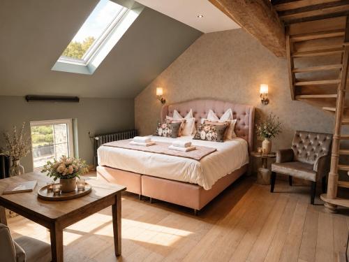 a large bedroom with a large bed and a table at Cha Cha de Loup-B&B-Vakantiewoning met verwarmd binnenzwembad en groot zonneterras in de Ardennen in Rendeux