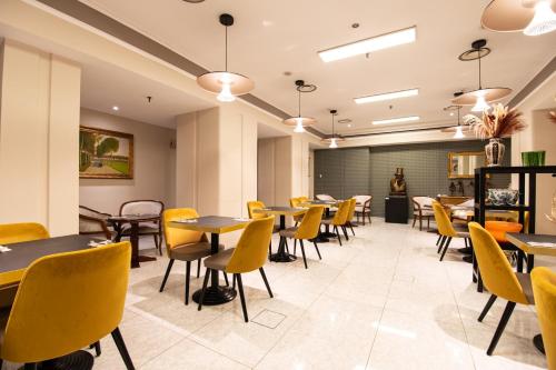 a dining room with tables and yellow chairs at Hotel Regina in Milan