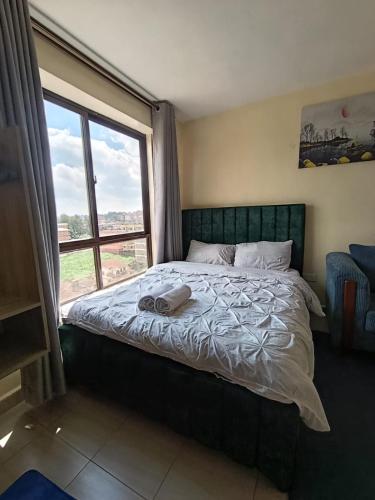 a bedroom with a bed with a large window at Majestic studio in Rungiri