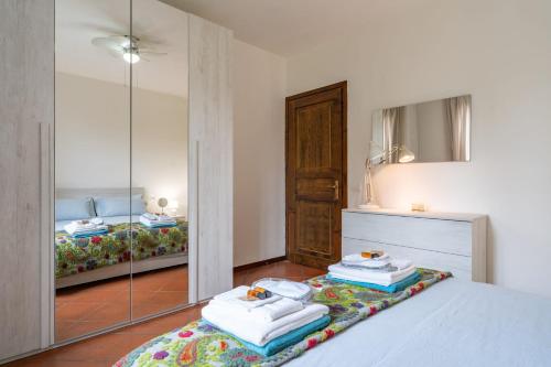 a bedroom with a mirror and a bed with towels at Casa Anna in Lierna