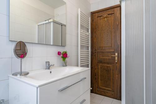 a bathroom with a sink and a wooden door at Casa Anna in Lierna